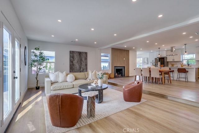 living area featuring light wood-style floors, recessed lighting, and plenty of natural light