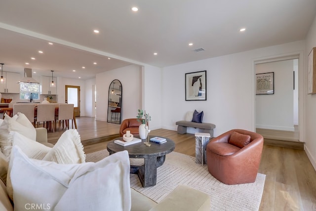 living area featuring recessed lighting, light wood-style flooring, and baseboards