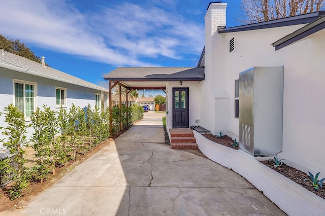 doorway to property featuring a chimney and stucco siding