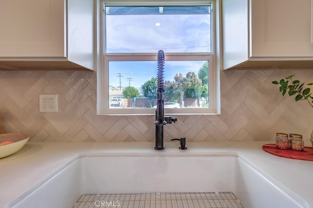 room details featuring light countertops, a sink, and white cabinets