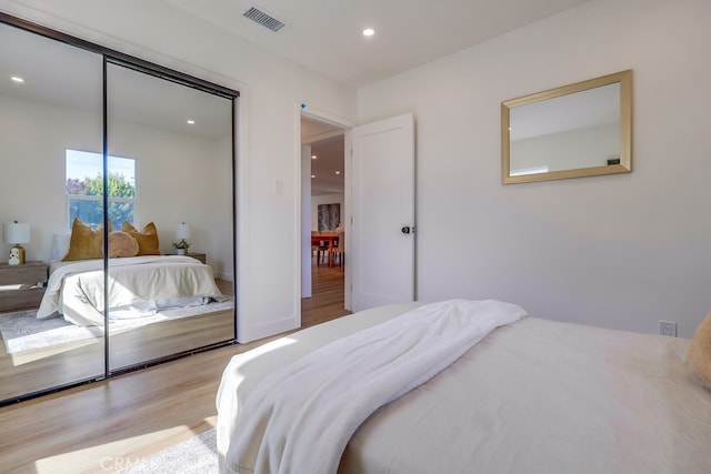 bedroom featuring recessed lighting, a closet, visible vents, and light wood-style flooring