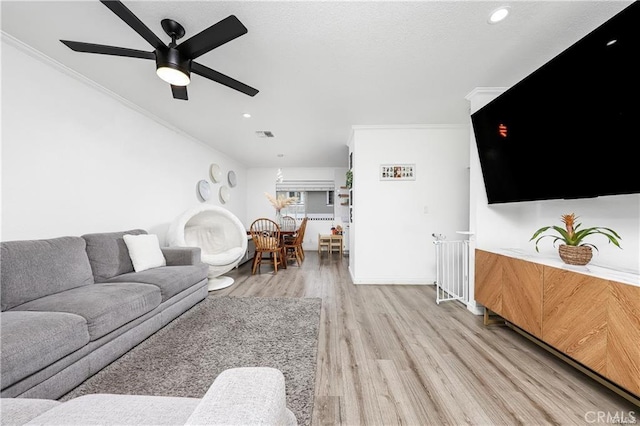 living area featuring crown molding, recessed lighting, visible vents, light wood-style flooring, and ceiling fan