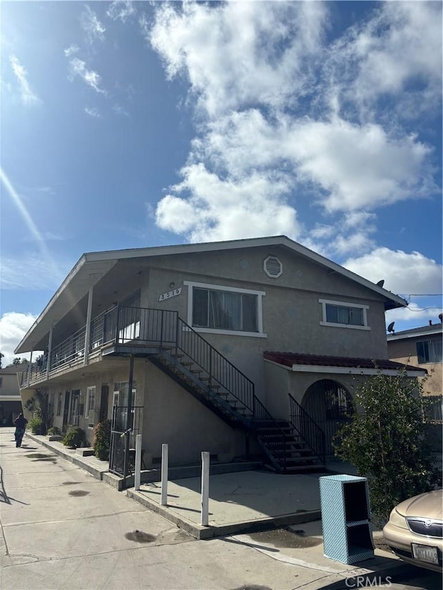 exterior space with stairway and stucco siding