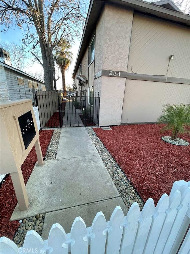 view of property exterior featuring fence, a gate, and stucco siding