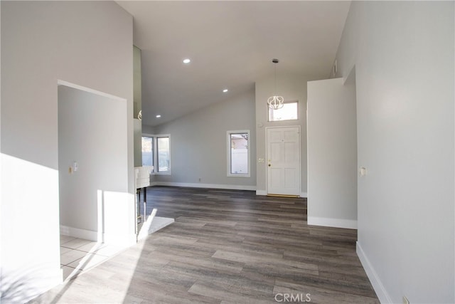 foyer with baseboards, high vaulted ceiling, wood finished floors, and recessed lighting