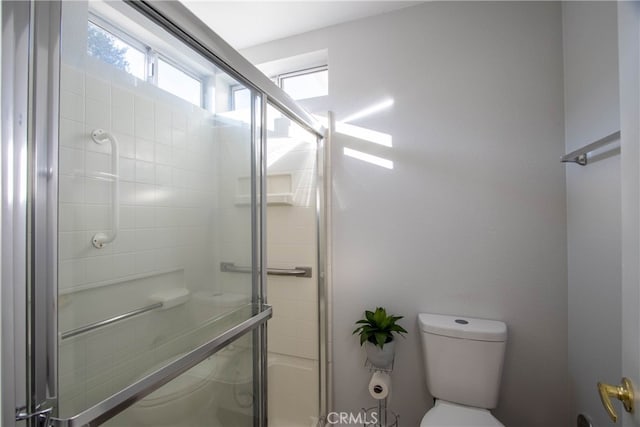 bathroom with toilet and an enclosed shower