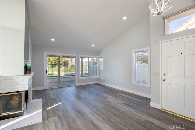 unfurnished living room featuring baseboards, dark wood-style floors, a fireplace, high vaulted ceiling, and recessed lighting