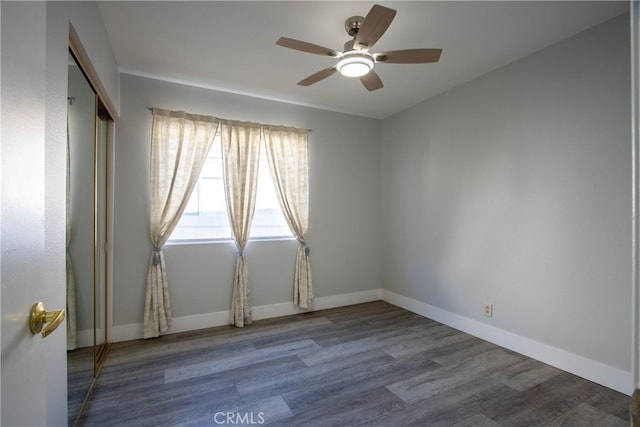 spare room with ceiling fan, baseboards, and wood finished floors