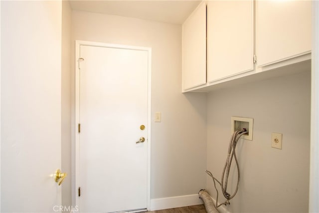 washroom featuring hookup for a washing machine, cabinet space, and baseboards