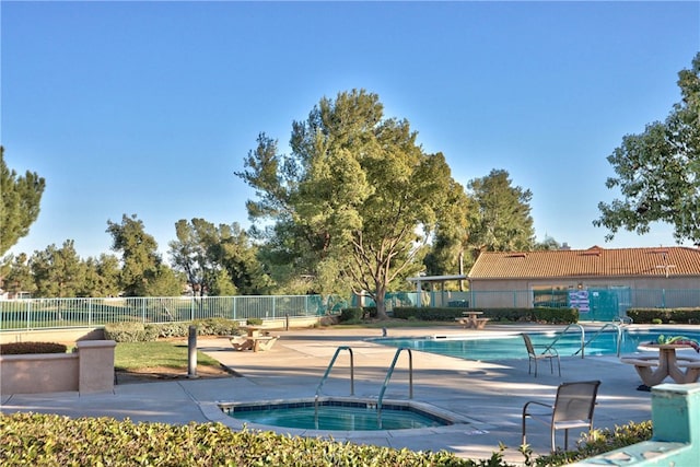 pool featuring fence, a community hot tub, and a patio