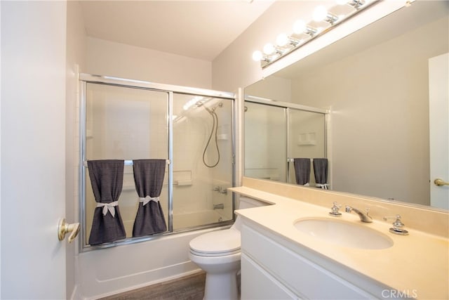 bathroom featuring shower / bath combination with glass door, vanity, toilet, and wood finished floors