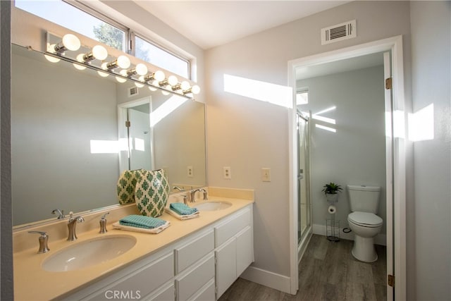 full bathroom featuring toilet, wood finished floors, a sink, and visible vents