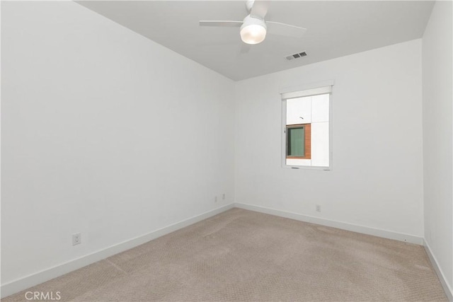 unfurnished room featuring light carpet, visible vents, baseboards, and a ceiling fan