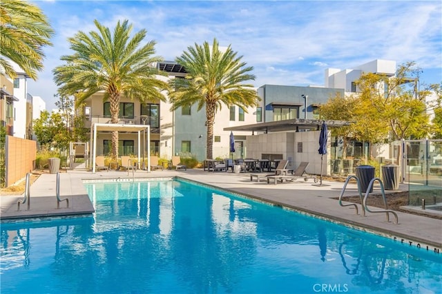 pool featuring fence and a patio