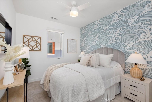 bedroom with baseboards, visible vents, a ceiling fan, and light colored carpet