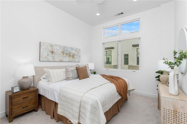 bedroom featuring recessed lighting, visible vents, a high ceiling, light carpet, and baseboards