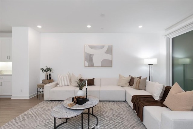 living area with baseboards, wood finished floors, and recessed lighting