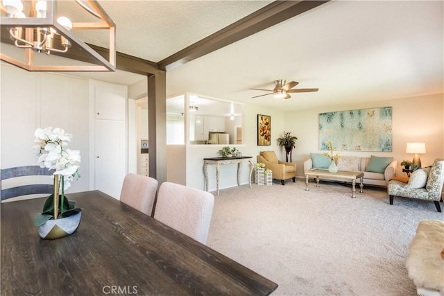 dining area featuring ceiling fan with notable chandelier, carpet floors, and a textured ceiling