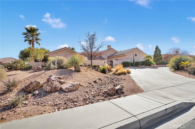 view of front of house featuring concrete driveway and fence