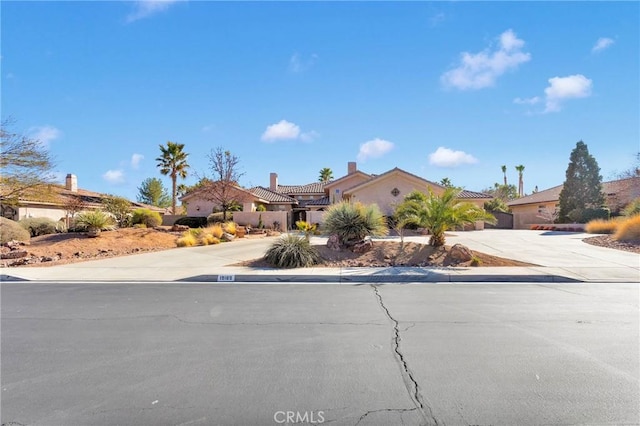 view of front of home featuring concrete driveway, a residential view, and stucco siding