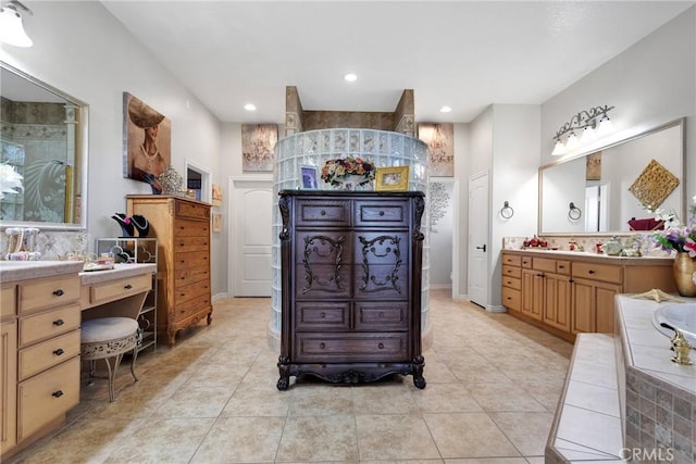 full bathroom with tile patterned flooring, recessed lighting, vanity, baseboards, and tiled tub