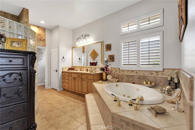 full bath with toilet, a jetted tub, tile patterned flooring, and vanity