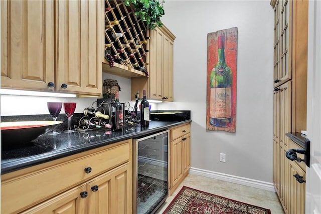 kitchen featuring beverage cooler, baseboards, and light brown cabinetry