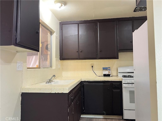 kitchen with a sink, light countertops, dark brown cabinets, decorative backsplash, and gas range gas stove