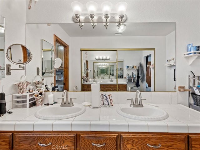 bathroom featuring double vanity, a sink, and visible vents