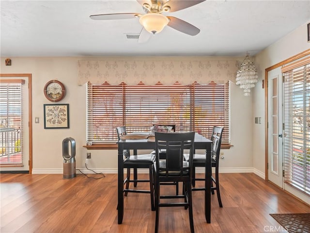 dining space with baseboards, wood finished floors, and a healthy amount of sunlight