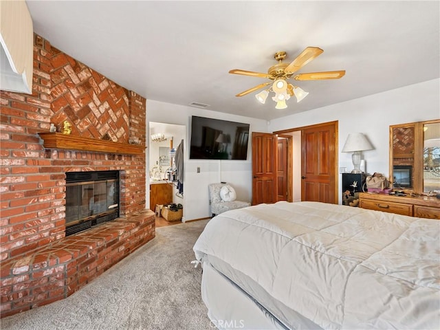 bedroom with light carpet, ceiling fan, and a brick fireplace