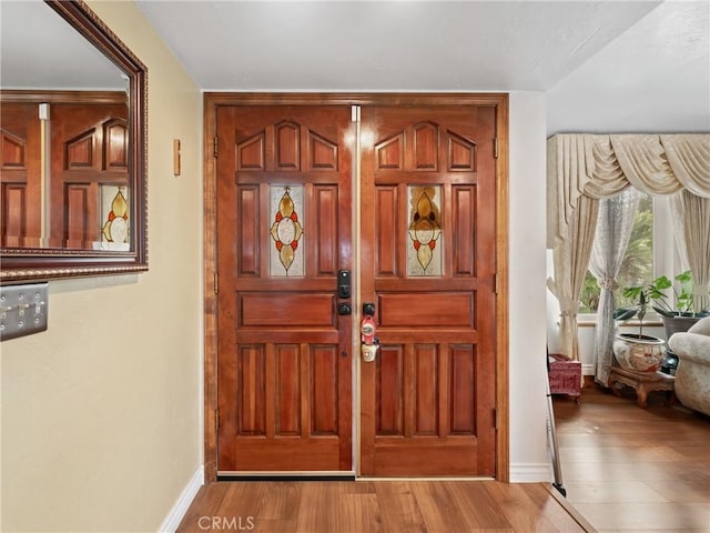 foyer featuring wood finished floors and baseboards