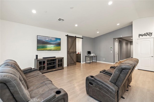 living area with a barn door, baseboards, vaulted ceiling, light wood-type flooring, and recessed lighting