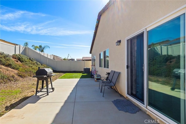 view of patio with central AC unit, grilling area, and a fenced backyard