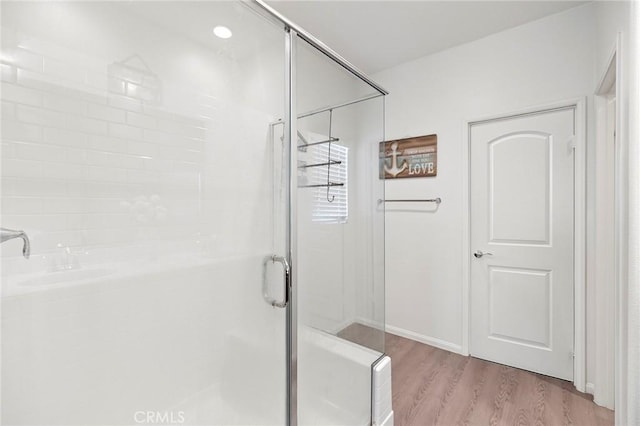 bathroom featuring a stall shower and wood finished floors