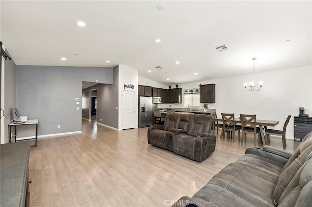 living area featuring lofted ceiling, recessed lighting, light wood-style floors, a chandelier, and baseboards