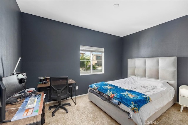 bedroom featuring light carpet and baseboards