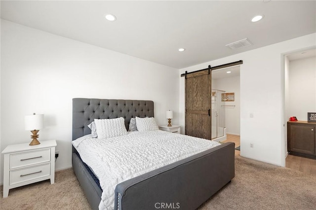 bedroom featuring recessed lighting, light colored carpet, visible vents, and a barn door