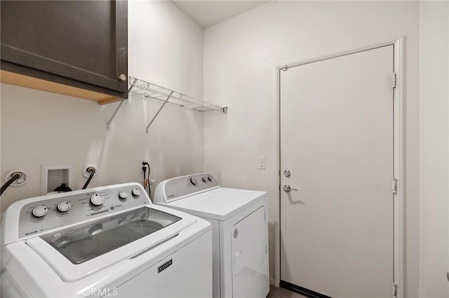 clothes washing area featuring washing machine and clothes dryer and cabinet space