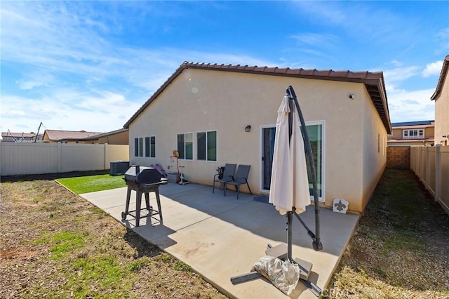 rear view of house featuring a fenced backyard, central AC, a patio, and stucco siding