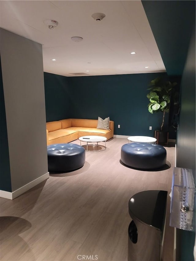 living room with baseboards, wood finished floors, and recessed lighting