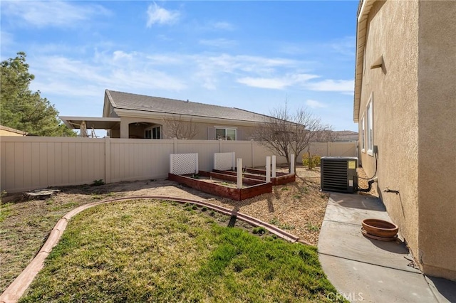 view of yard featuring a fenced backyard, a vegetable garden, and central air condition unit