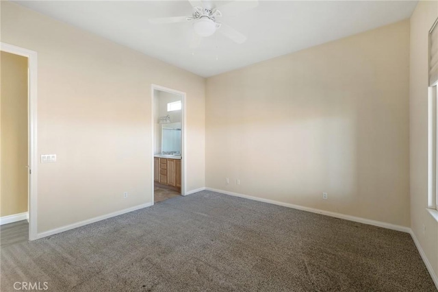 carpeted empty room featuring ceiling fan and baseboards