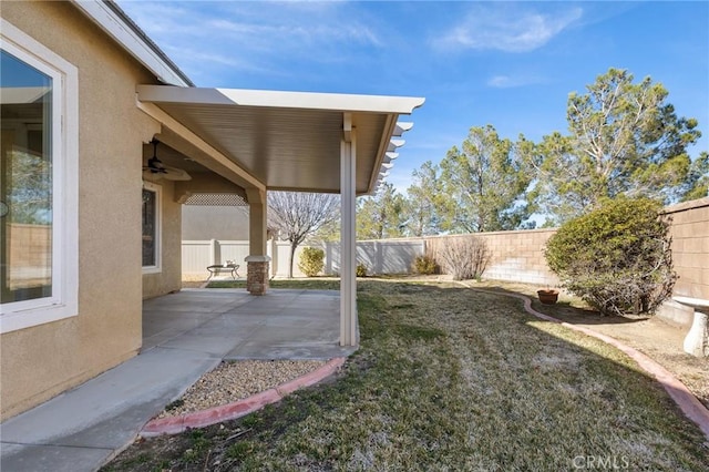 view of yard featuring a fenced backyard, a ceiling fan, and a patio