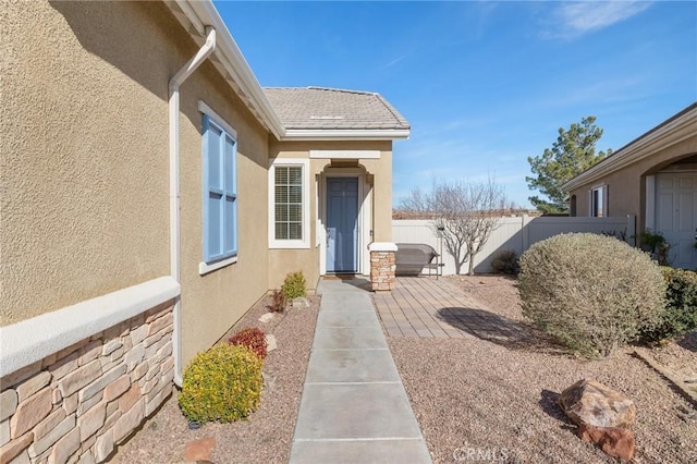 view of side of home with a patio, roof with shingles, fence, and stucco siding