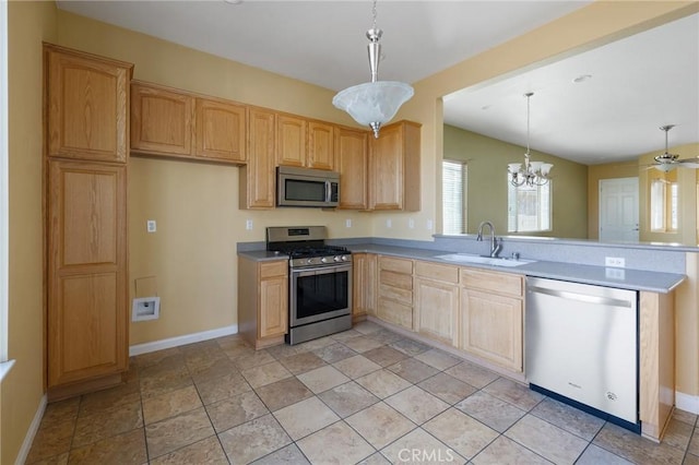 kitchen featuring a sink, light countertops, appliances with stainless steel finishes, hanging light fixtures, and light brown cabinetry