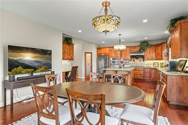 dining space featuring baseboards, dark wood finished floors, and recessed lighting