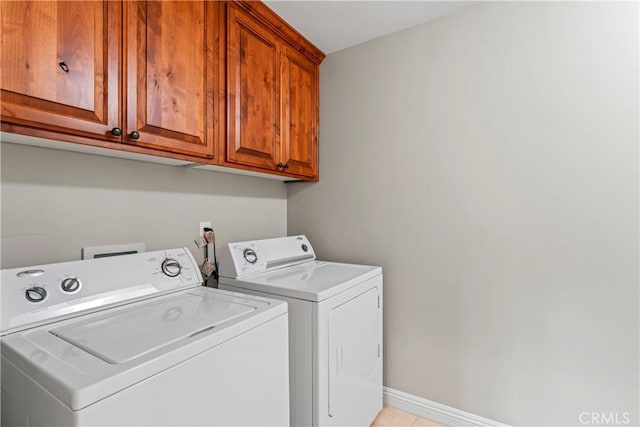 washroom with cabinet space, light tile patterned floors, baseboards, and separate washer and dryer