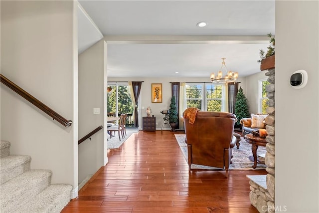 foyer entrance with stairs, baseboards, an inviting chandelier, and wood finished floors