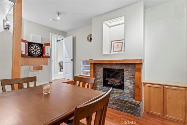 dining space with light wood-type flooring and a fireplace